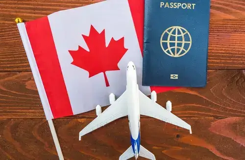 Passeport canadien sur la table à côté du drapeau canadien et d'un avion jouet